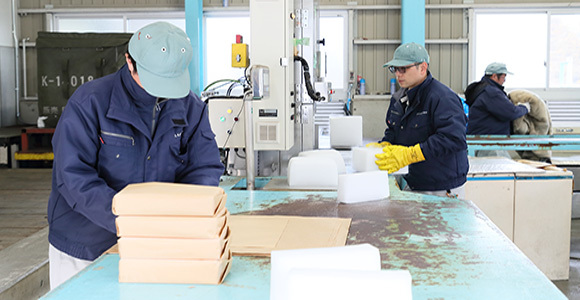 写真：工場内でドライアイス製造を行う男性たち
