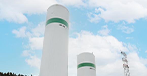 写真:青空の下そびえたつガス貯蔵タンク