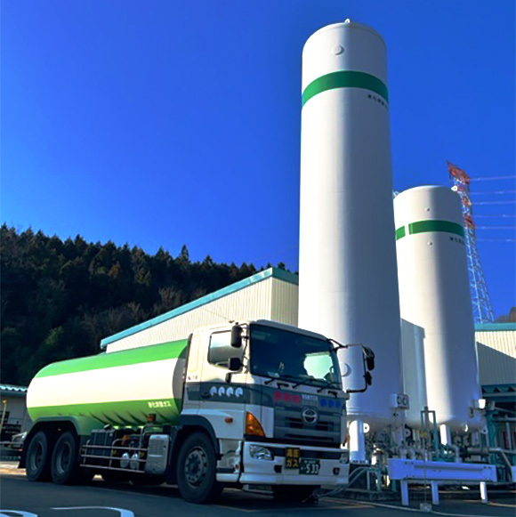 写真:青空の下のガス貯蔵タンクとダンプ